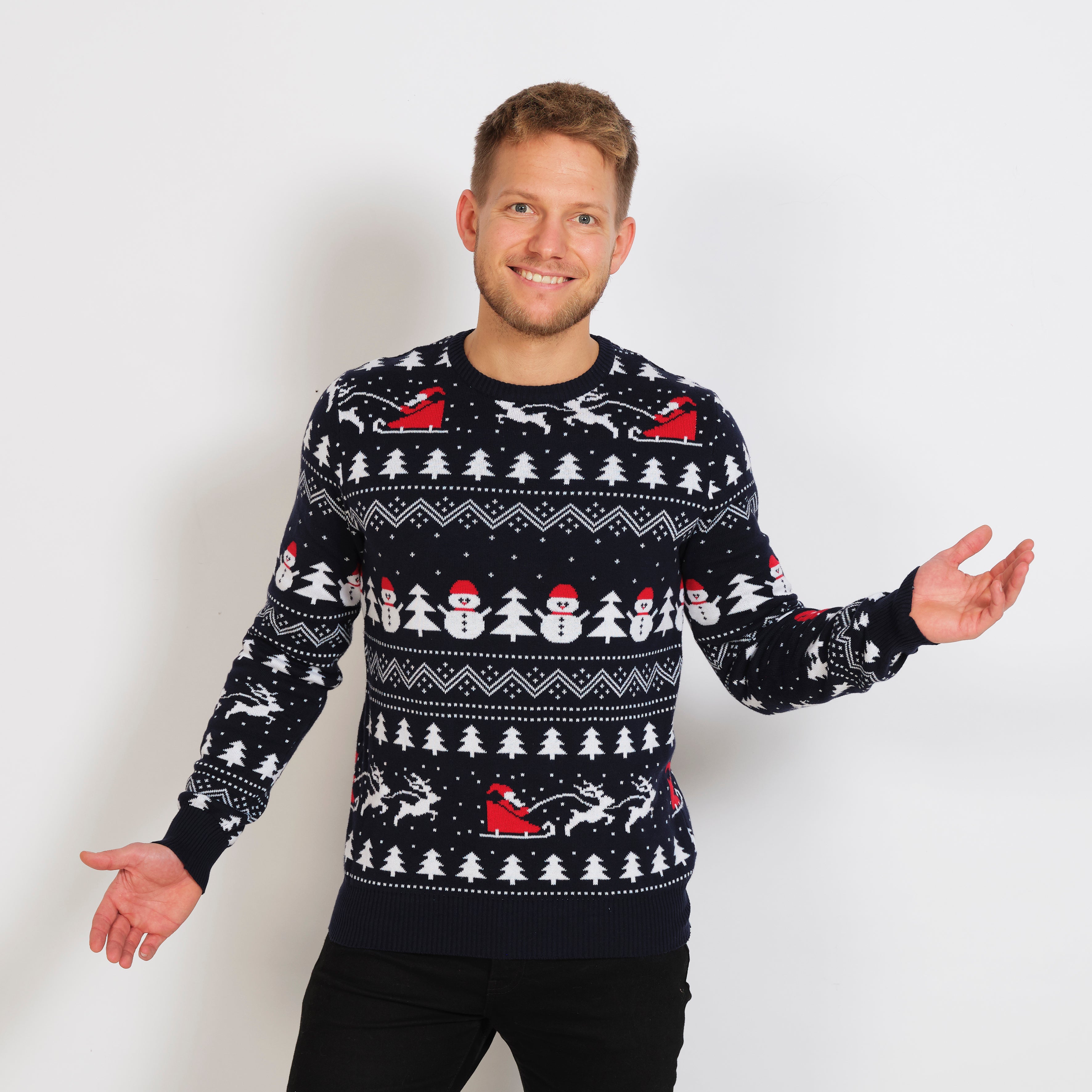 Ein Mann trägt einen schwarzen, gemusterten Weihnachtspulli.